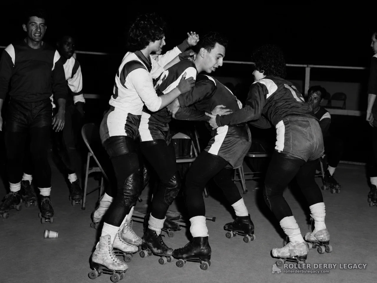 Roller Derby Skaters Grapple on an Indoor Rink