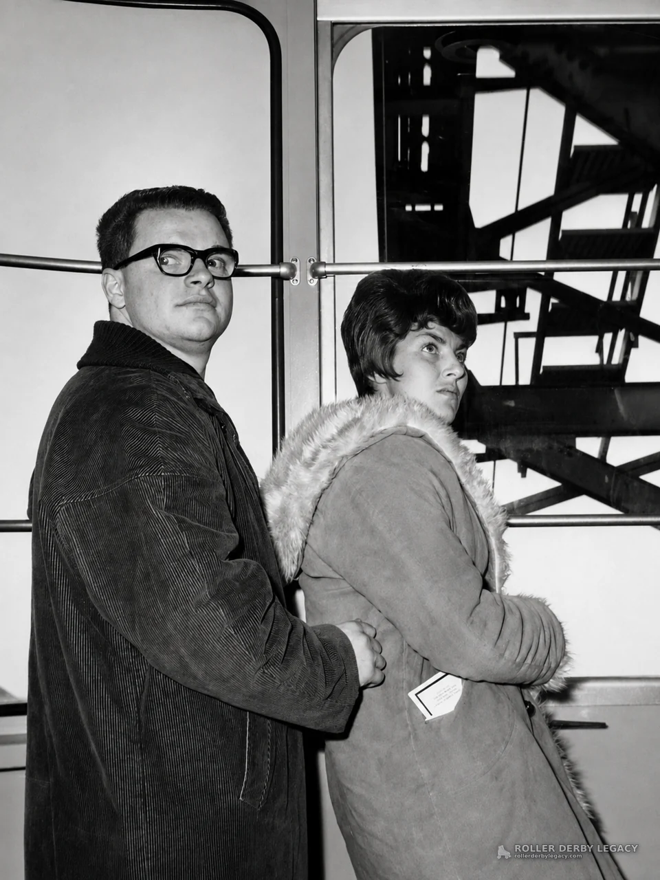 Two People in Coats by Interior Windows