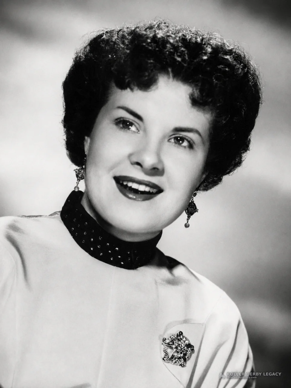 Black-and-white studio portrait of smiling woman
