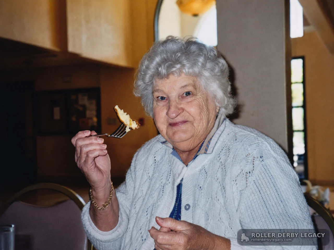 Older Woman Holding a Fork in an Indoor Dining Room