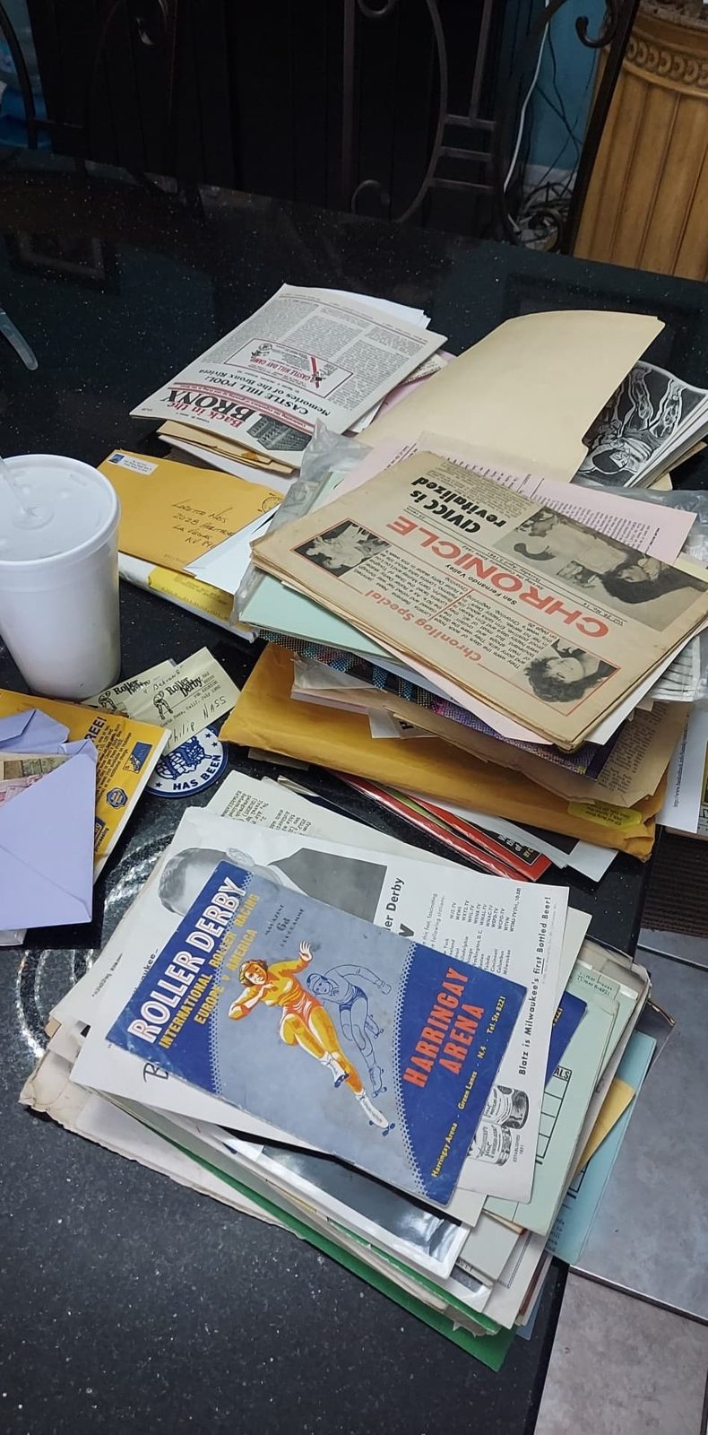 A stack of documents and magazines, including original printed materials.
