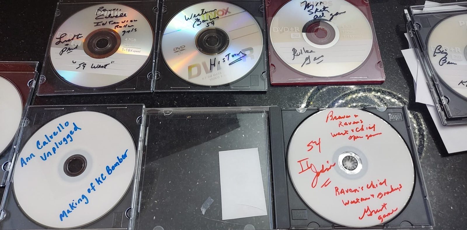 Hand-labeled DVDs and discs holding recorded footage.
