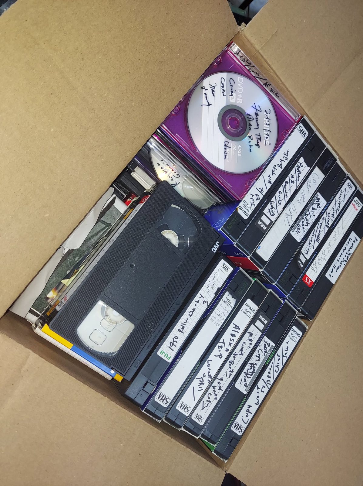 VHS tapes and optical discs stored together.